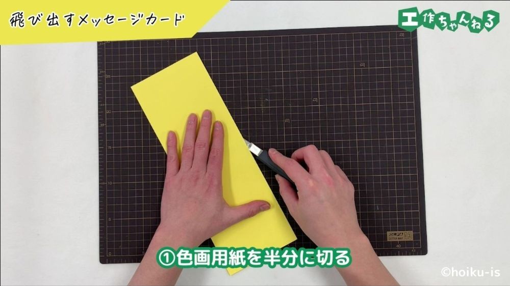 カッターで画用紙を切っている手元