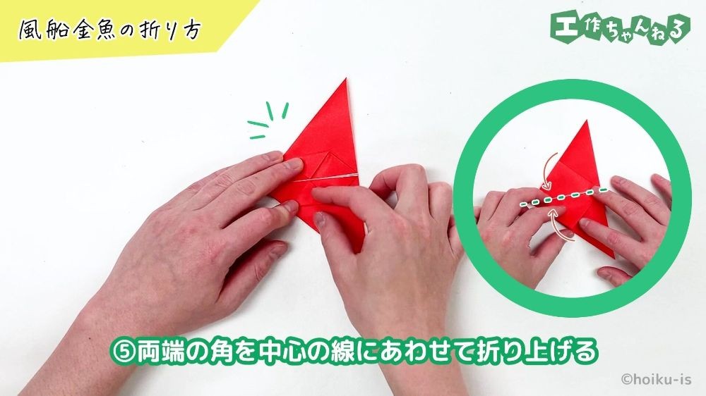 折り紙の角を折り曲げている手元