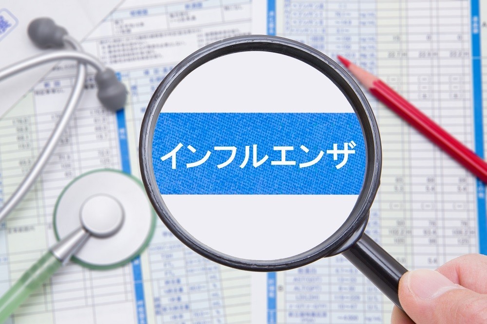 虫眼鏡で拡大された「インフルエンザ」の文字