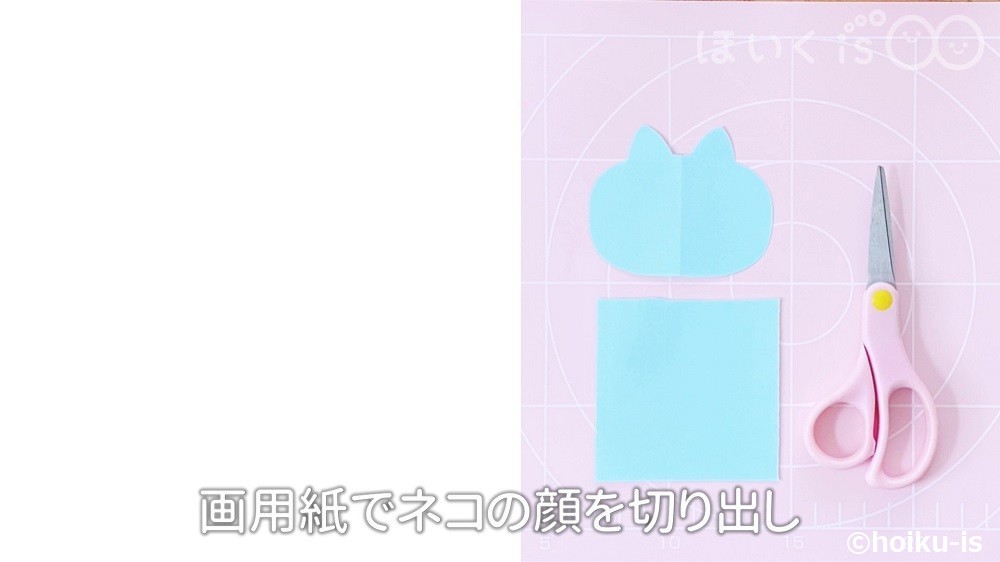 画用紙でネコの顔を切り出している場面