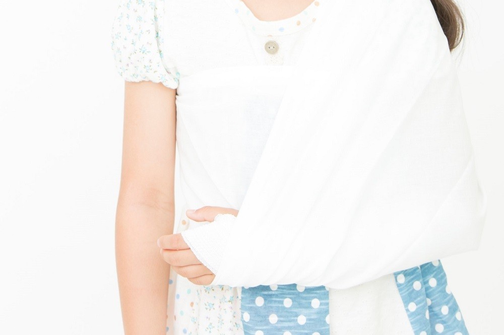 左手を包帯で巻いている子ども