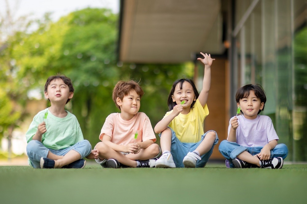 手を挙げている女の子とそのお友だち