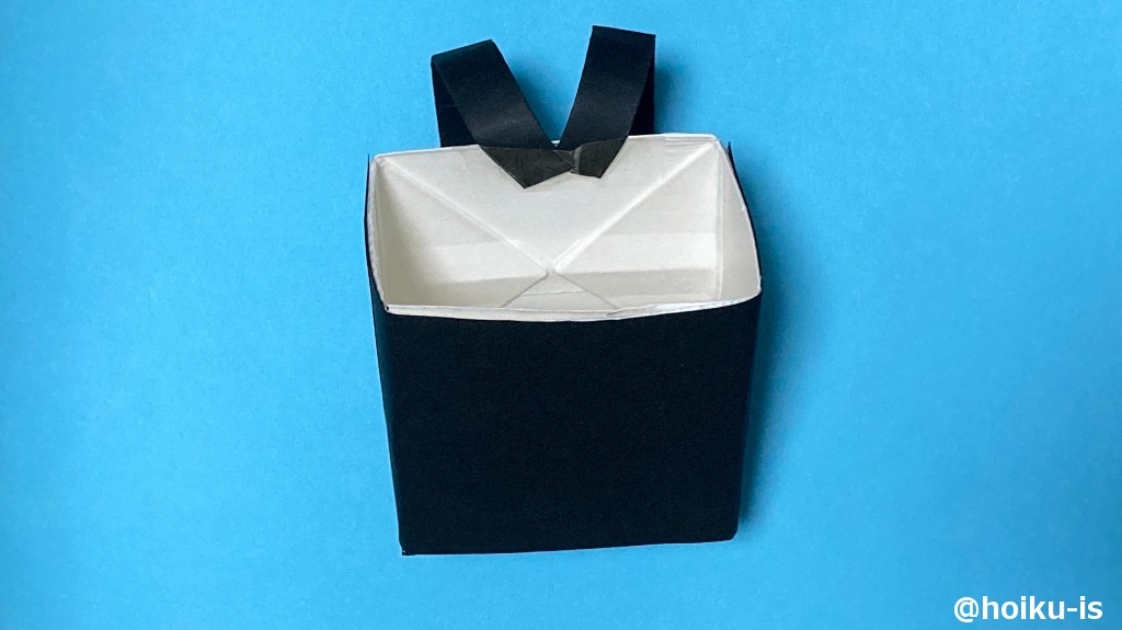 13、はみ出ている部分の折り紙を切る。