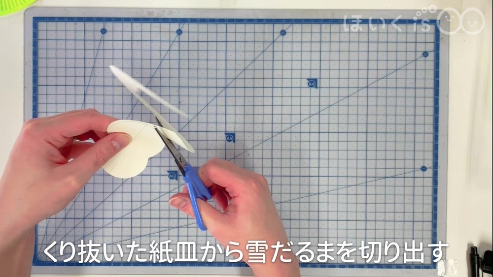 くり抜いた紙皿から雪だるまを切り出す
