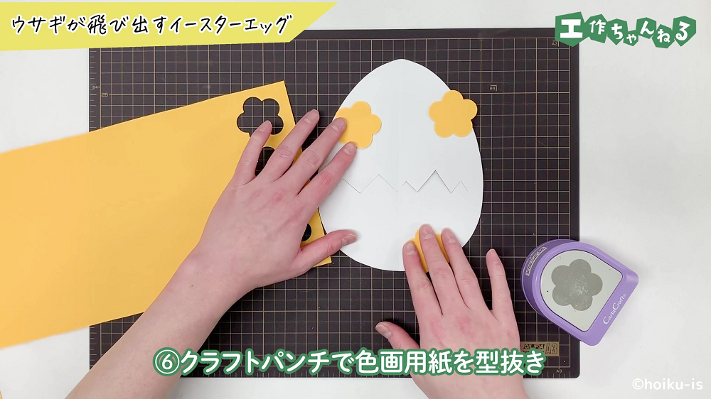 お花型に型抜きした画用紙を並べている手