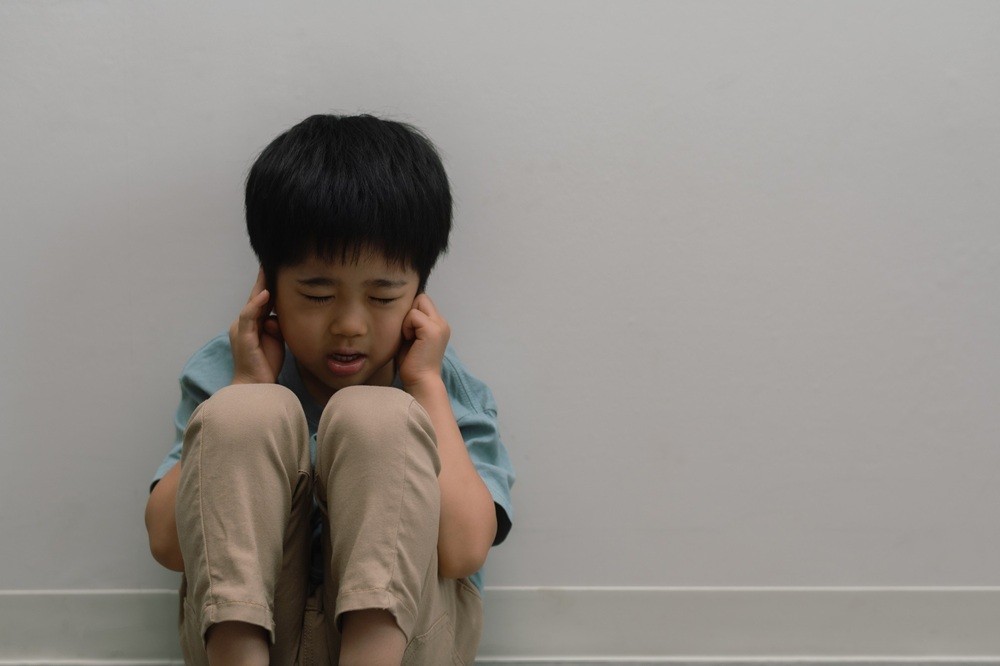 両耳をふさいでいる男の子