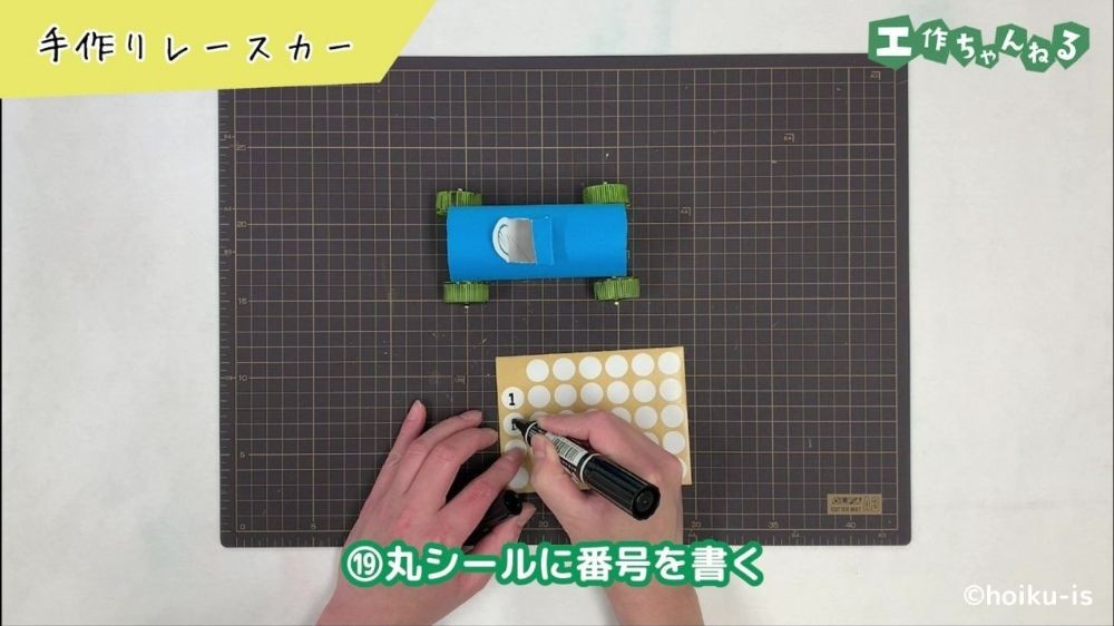 シールに番号を書いている手元