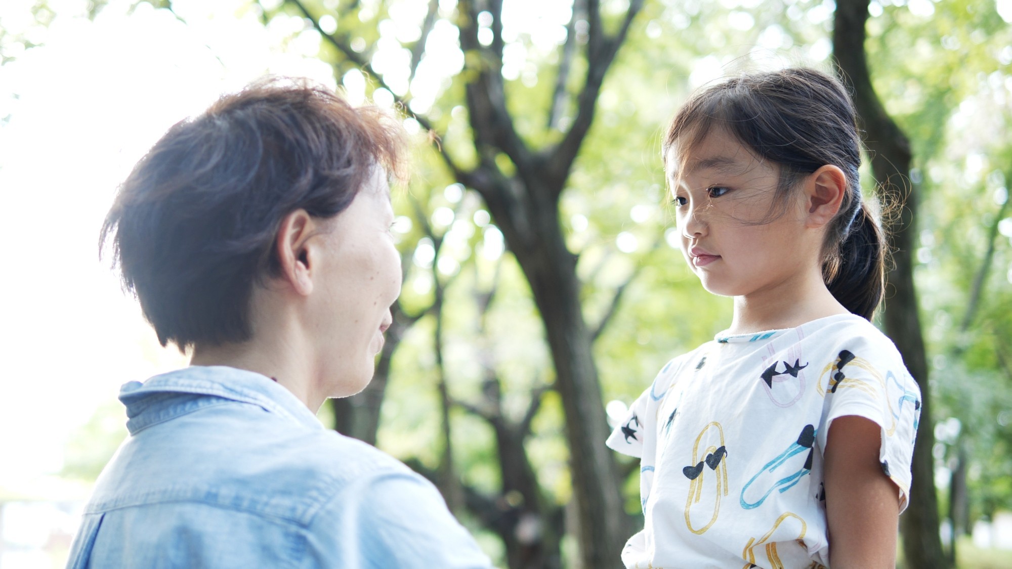 向き合って話す女性と子ども