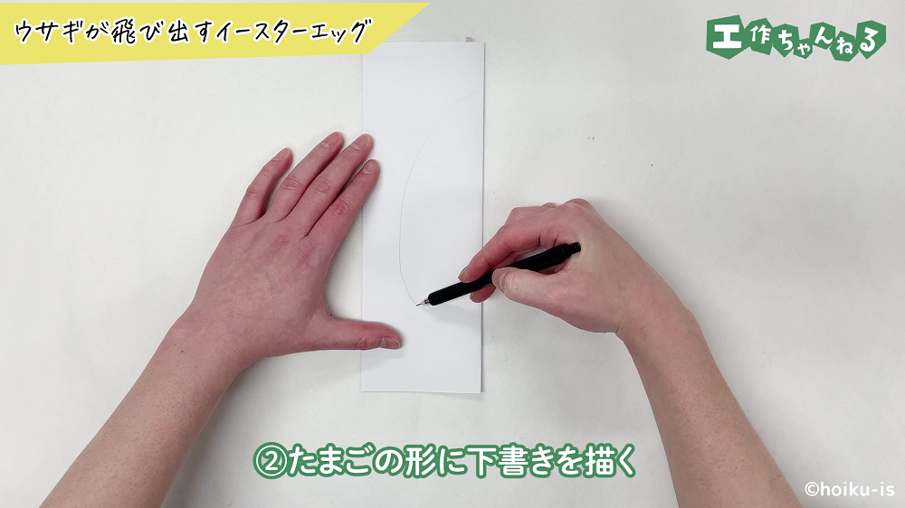 ペンでたまごの形に下書きを描いている手