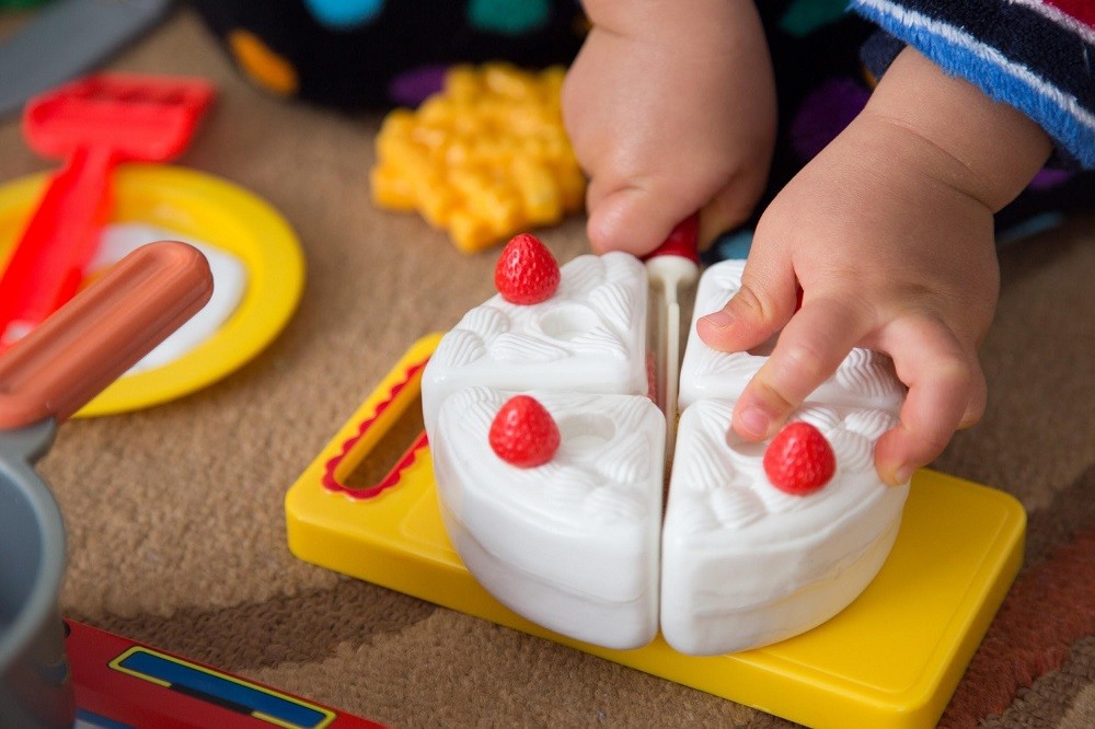 おもちゃのケーキで遊んでいる子ども