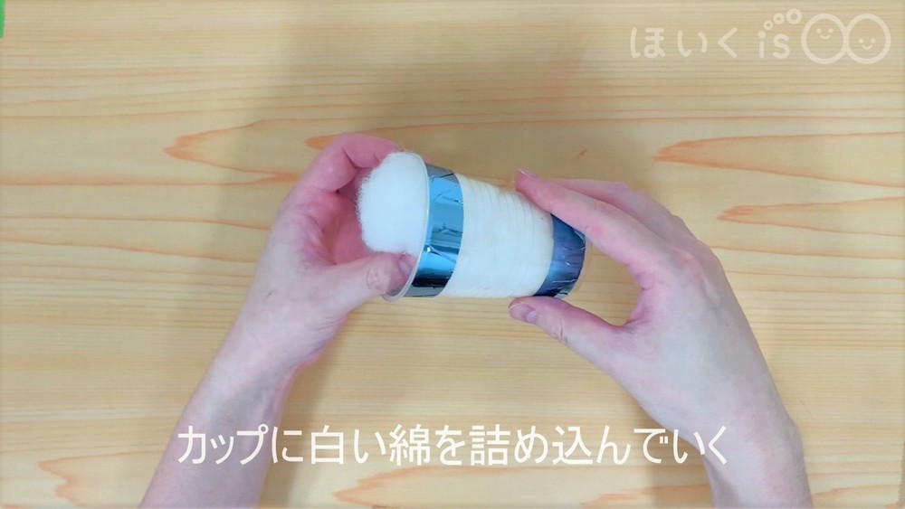 カップに白い綿を詰め込んでいく