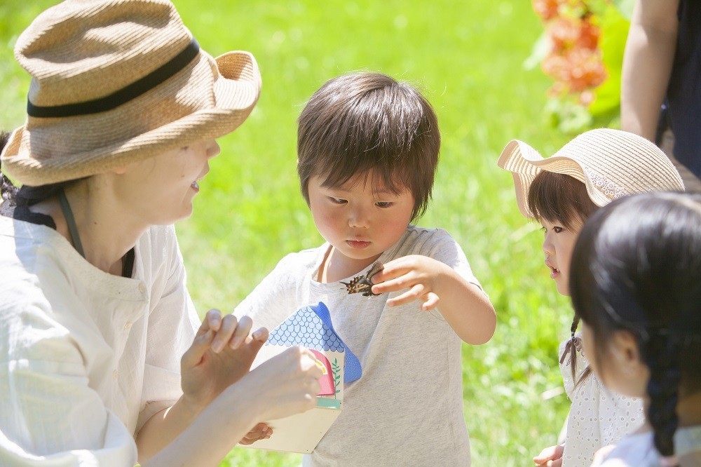 屋外活動をしている子どもたちと先生