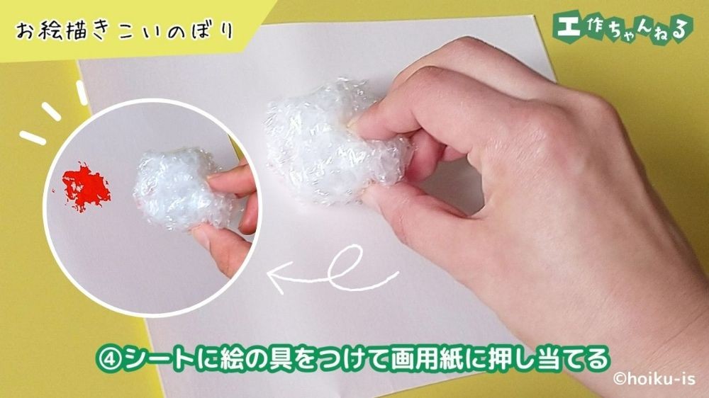 画用紙にプチプチシートでスタンプをしている手元