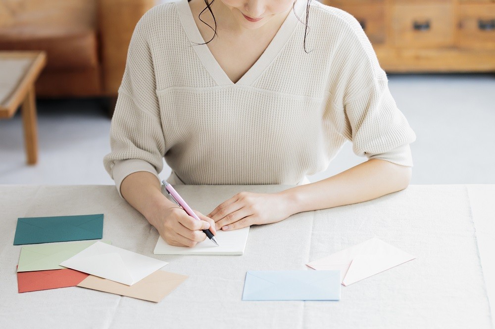 手書きのお礼状を書いている女性