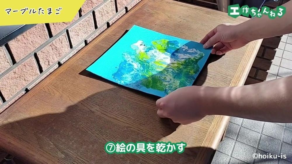 画用紙に塗った絵具を乾かしている手元