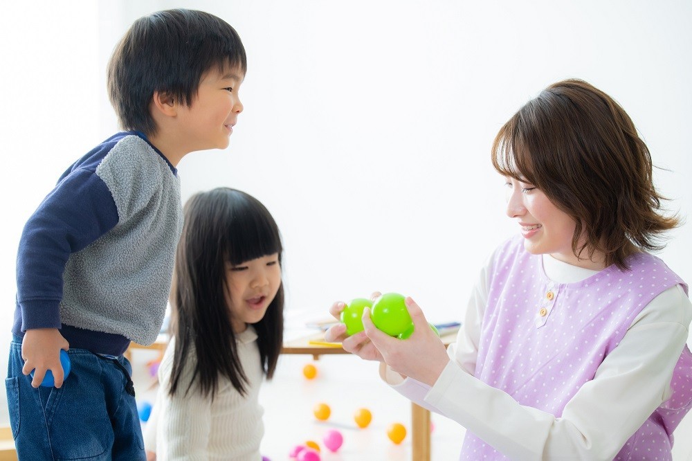 子どもたちに遊びの説明をする保育士