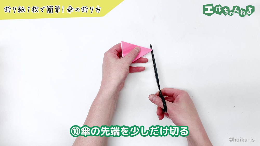 折り紙の先端をハサミで切っている手元