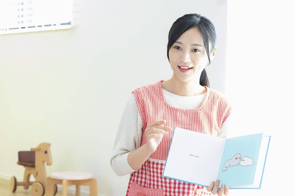 絵本を読み聞かせする保育士