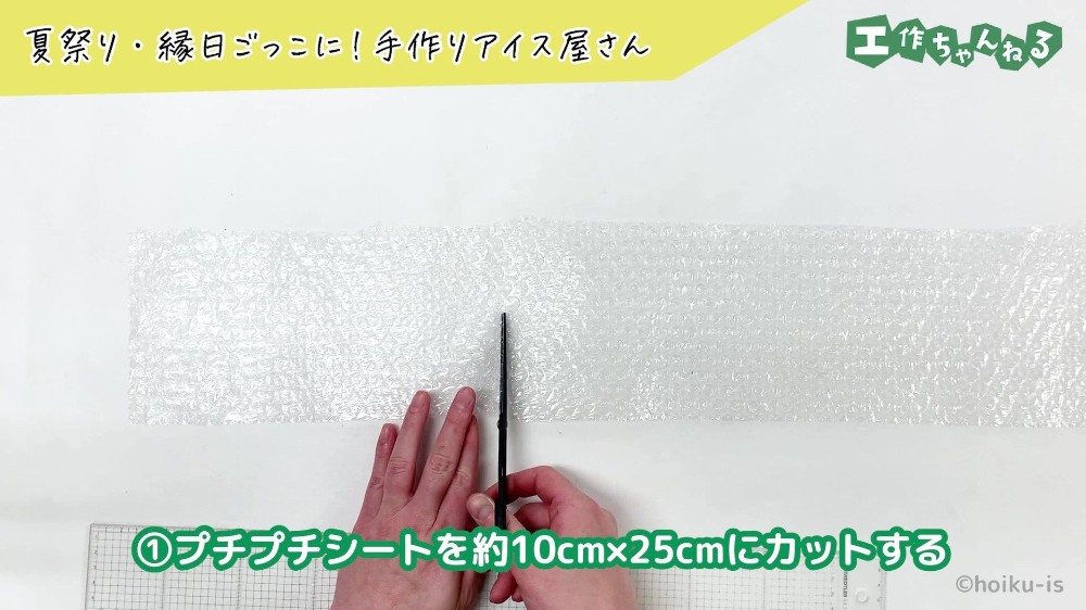 ハサミでプチプチシートを切っている手元