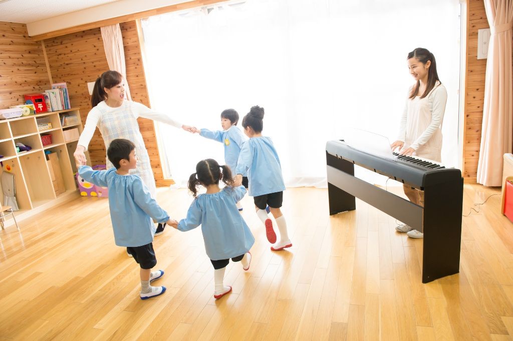 リトミックをする保育士と園児