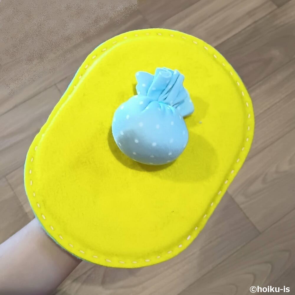 「ミトン型羽子板」でボールを打っているところ