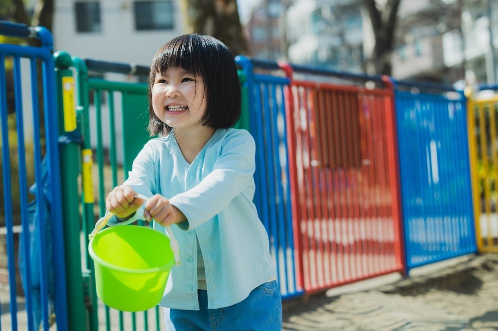 緑色のバケツを持っている女の子