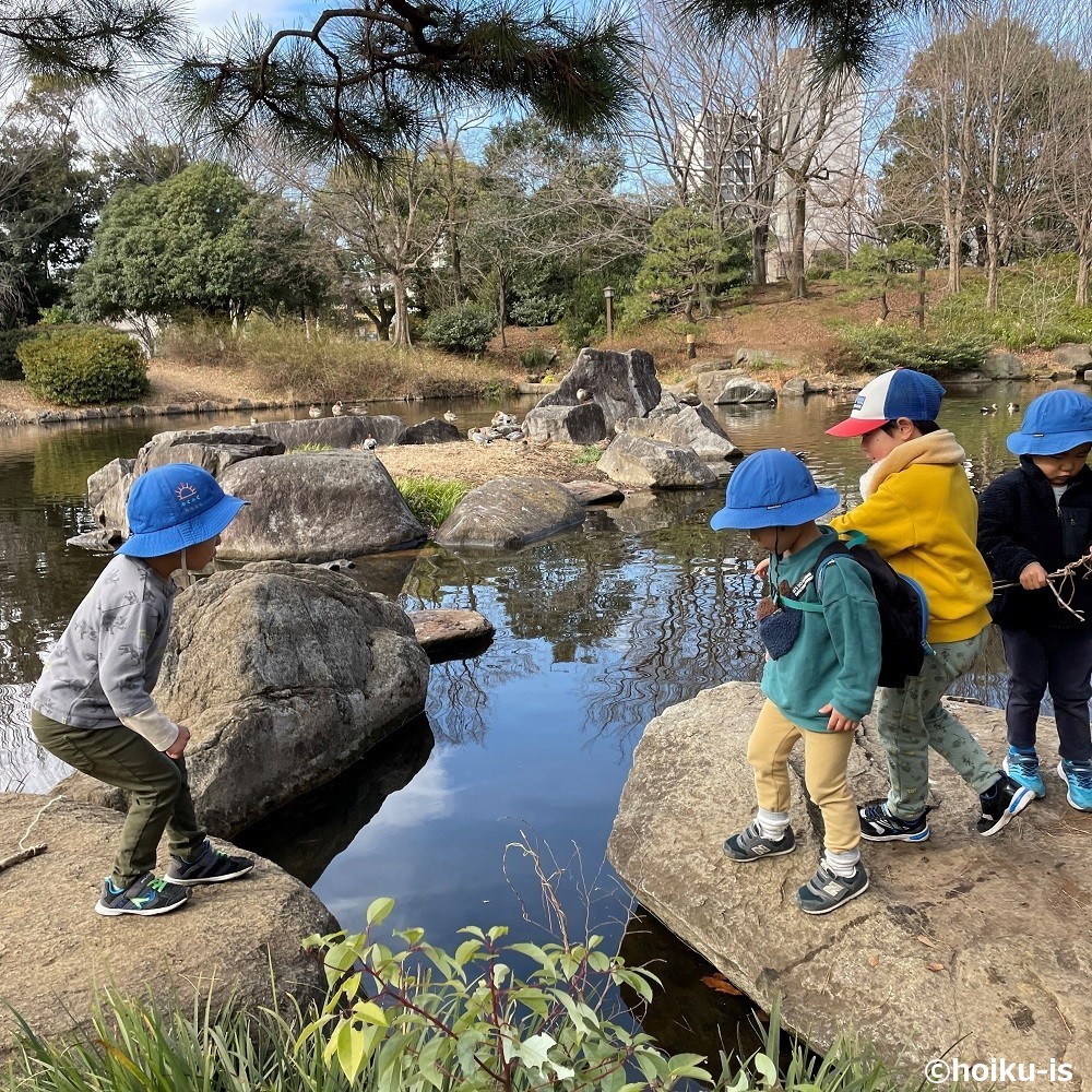 岩と岩を飛び越えようとする子ども