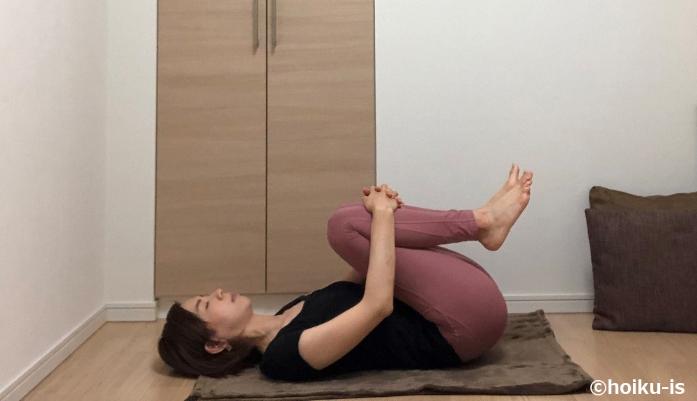 両ひざを抱えて左右にゴロゴロと体を揺らすポーズ