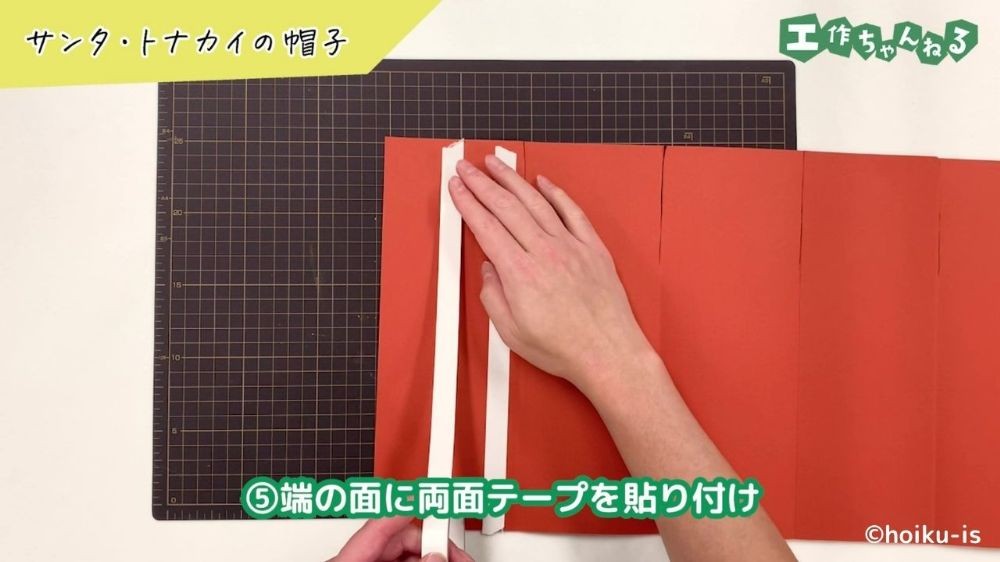 両面テープを貼り付けている手元