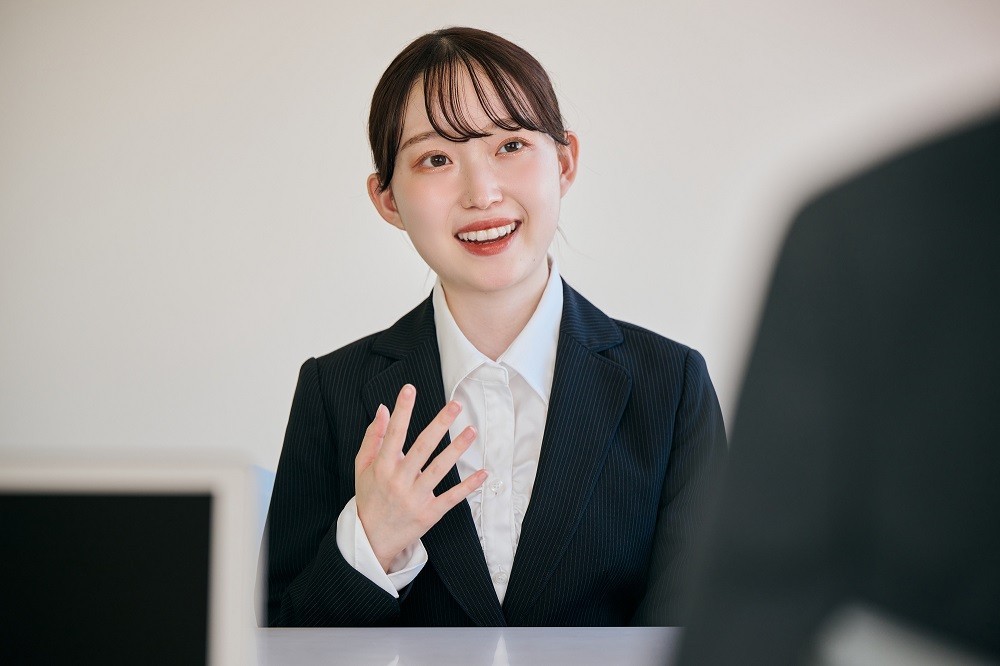 リクルートスーツ姿で面接試験を受ける女性
