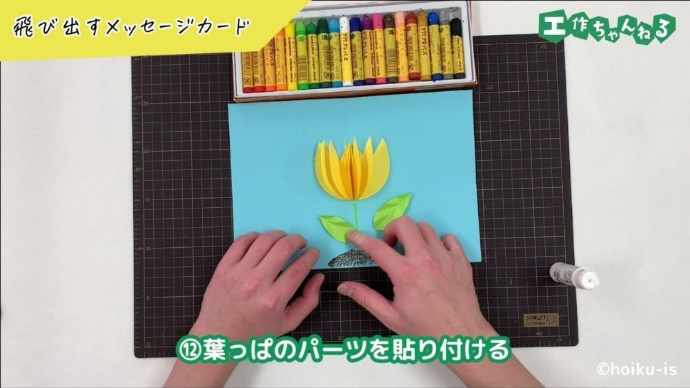 のりで葉っぱのパーツを貼り付けている手元