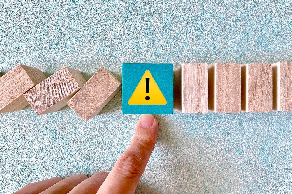 倒れてくるドミノを止めている「！」マークの入った積み木