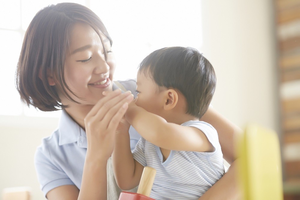 子どもを抱っこする保育士
