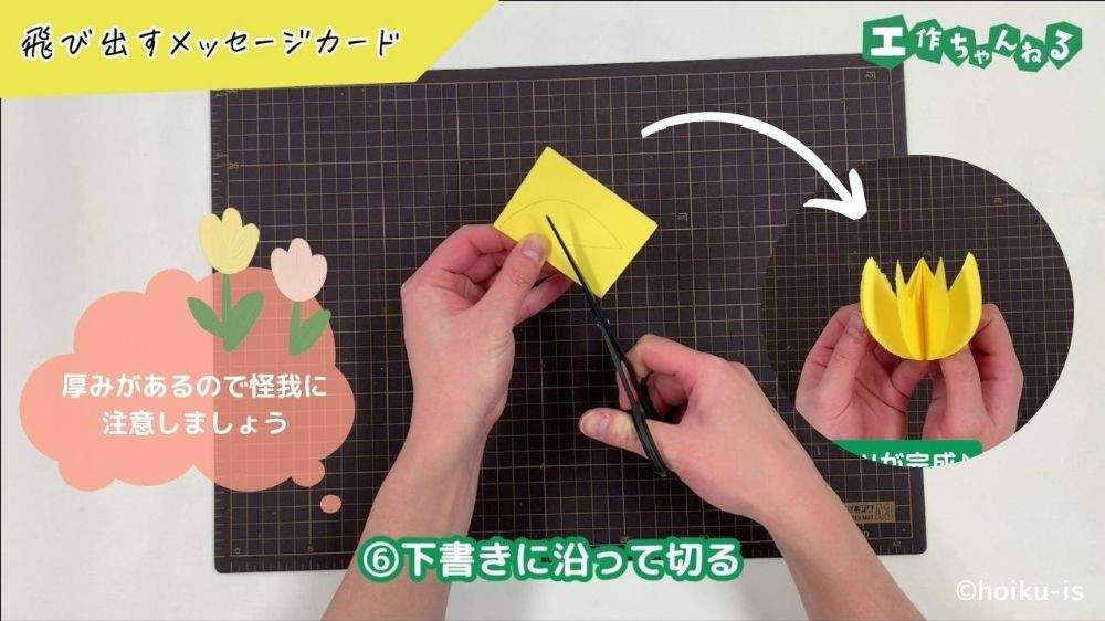 はさみで画用紙を切り取っている手元