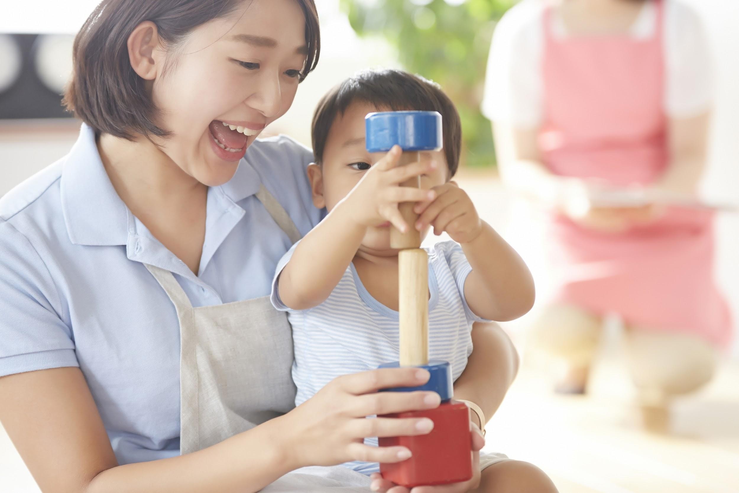 子どもと一緒におもちゃで遊ぶ保育士