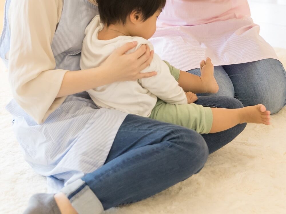 子どもをだっこする保育士