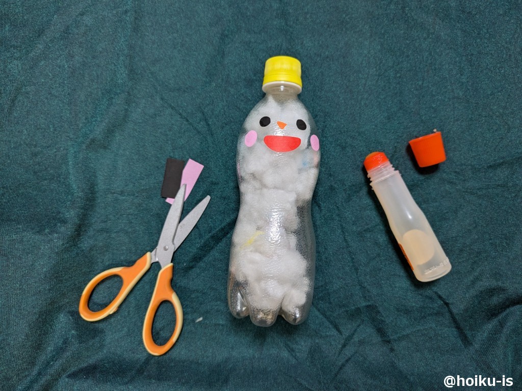 ②折り紙で顔のパーツを切り取り、のりで貼り付けます。