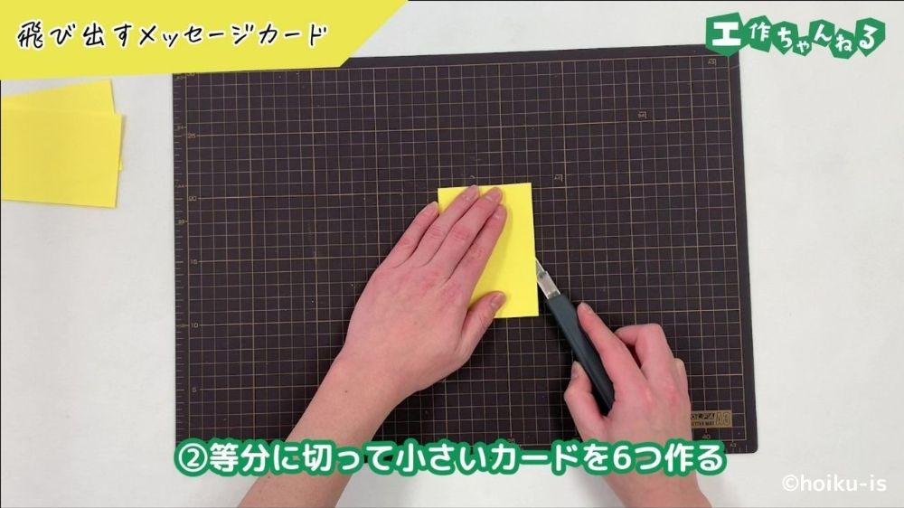 カッターで画用紙を切っている手元