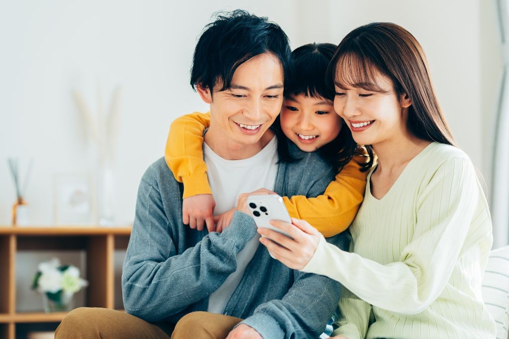 写真販売サービスを使って写真を選ぶ家族