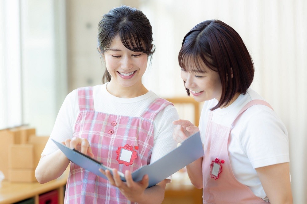 書類を見ながら会話を交わす保育士たち