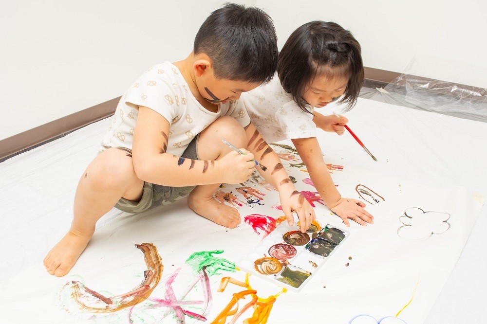 フィンガーペインティングで遊んでいる子どもたち