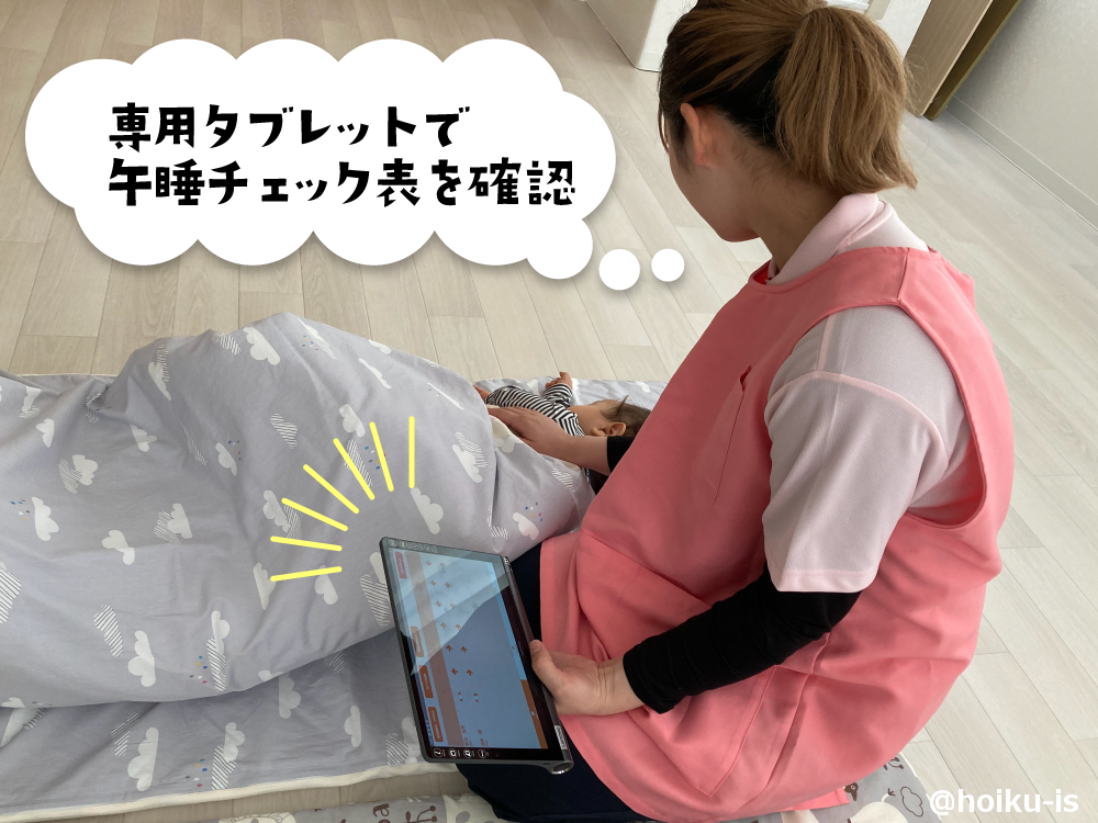 午睡チェックをする保育士の画像