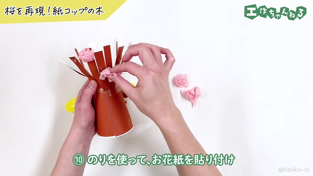 紙コップに丸めたお花紙を貼り付けている様子