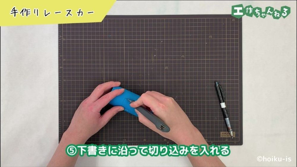 カッターで切り込みを入れている手元