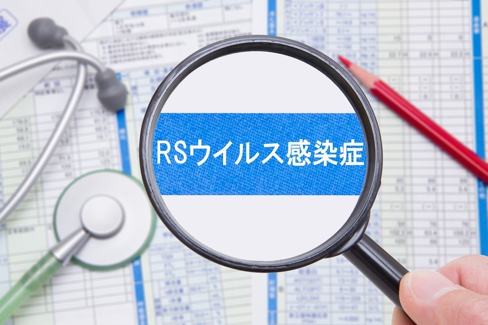 虫眼鏡で拡大された「RSウイルス感染症」の文字