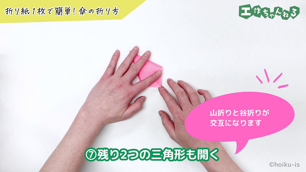 折り紙を押さえながら折っている手元