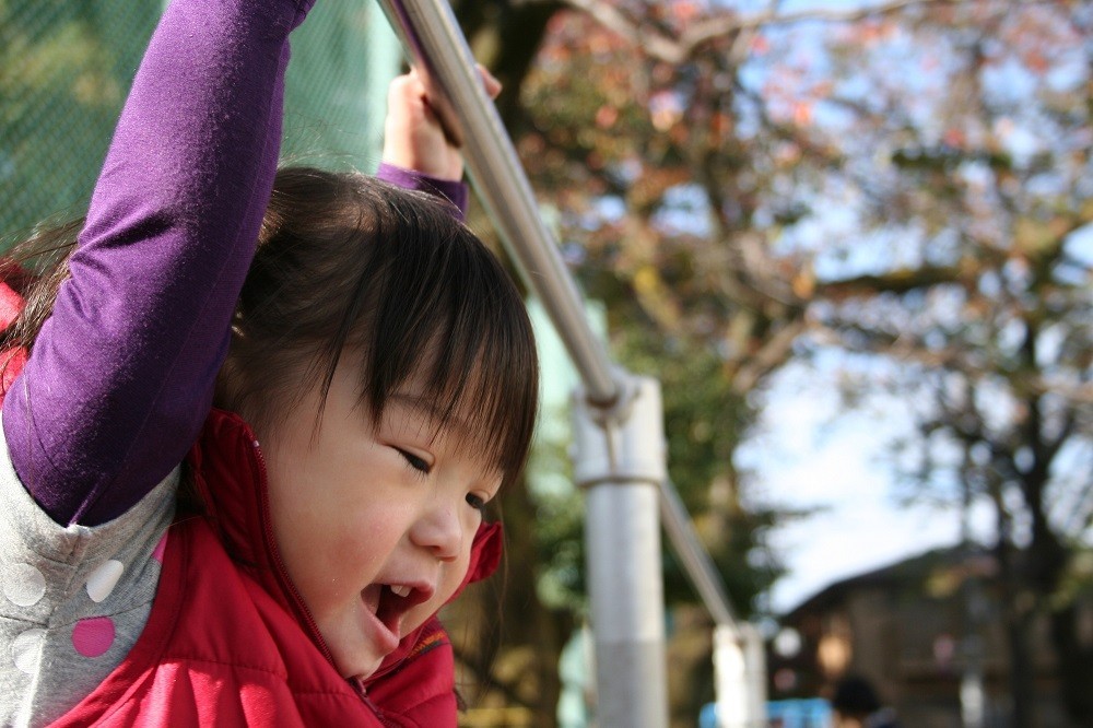 鉄棒にぶら下がっている女の子