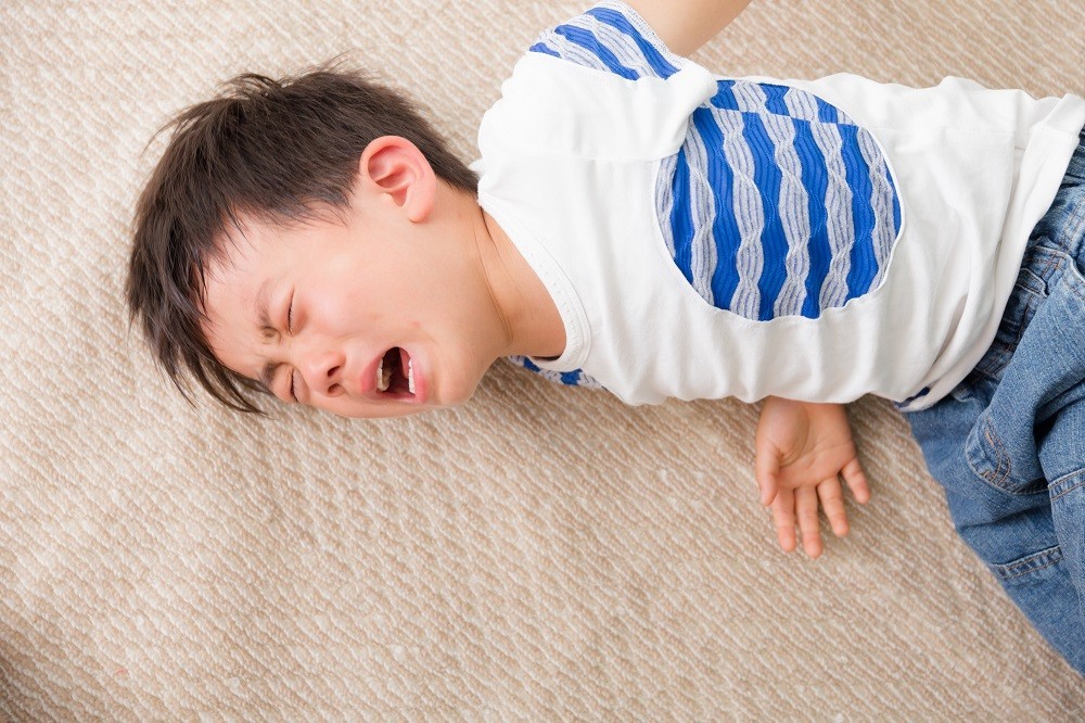 床に倒れ込んで泣いている男の子