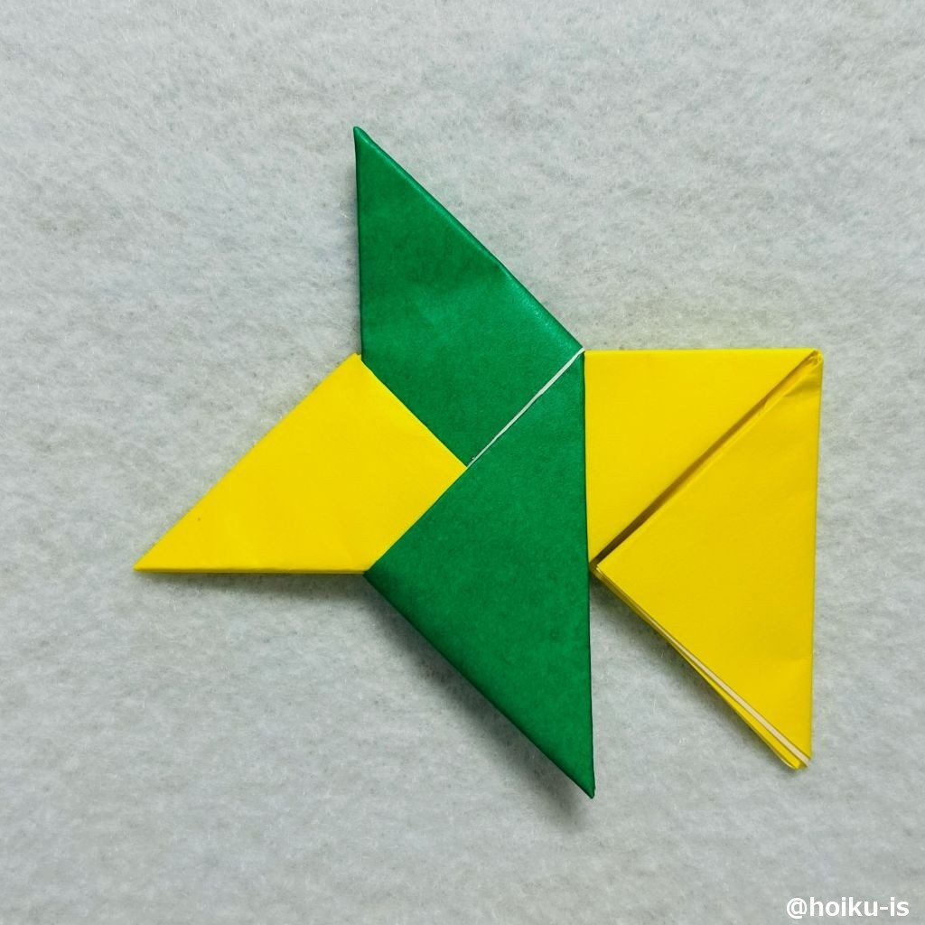 ⑯⑪と同じように上の三角形を中心に向かって折り、緑色の折り紙に差し込む。