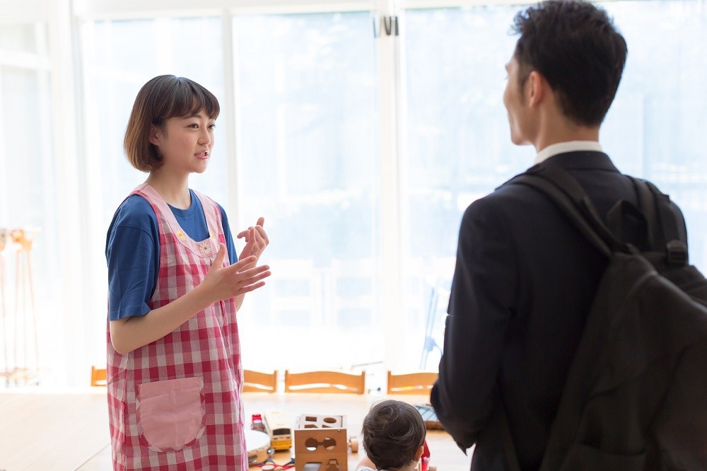 保護者に説明をする保育士
